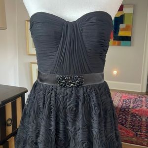 Black strapless gown with jeweled detail at waist.
